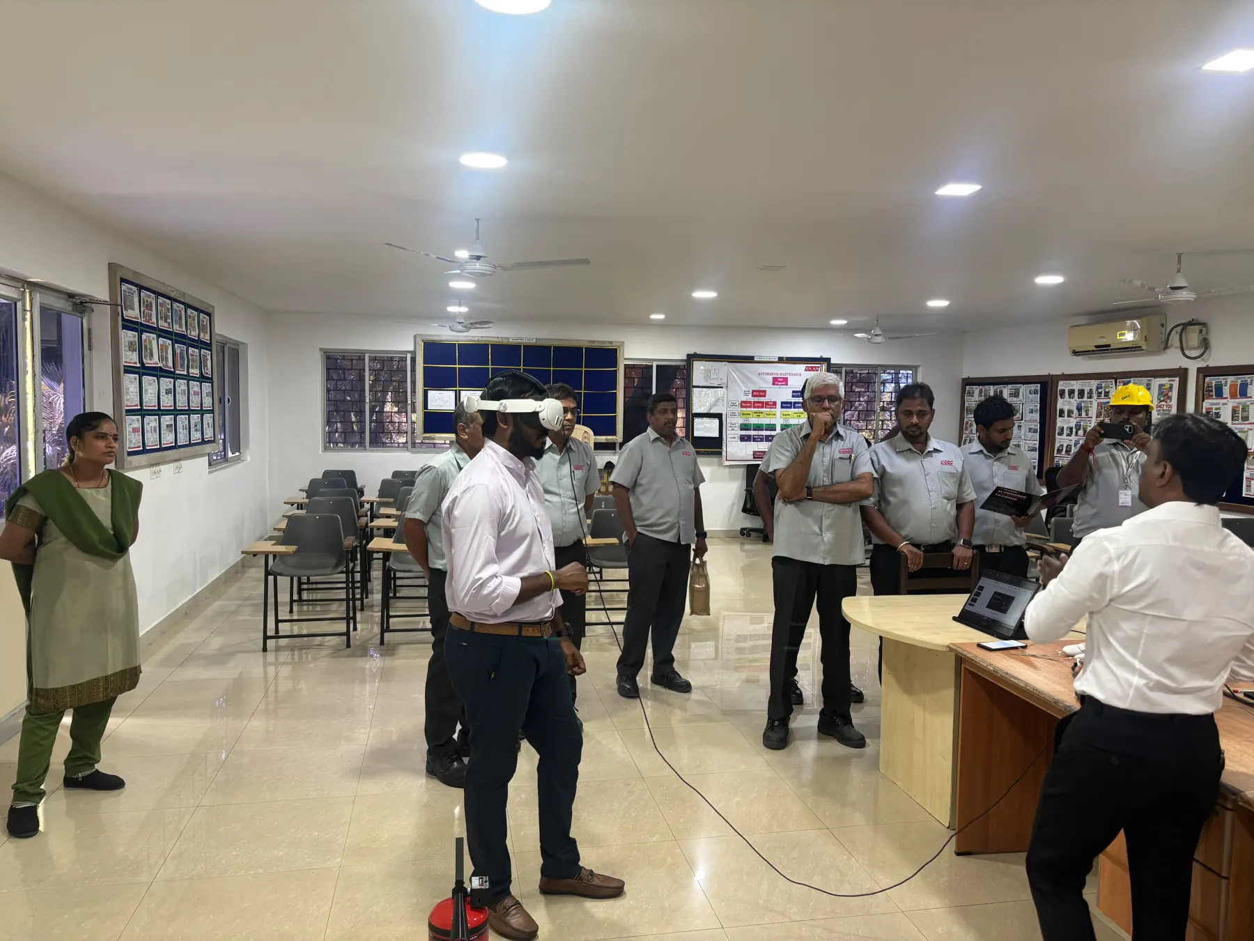 Employee wearing a headset as an instructor introduces training to a workplace team